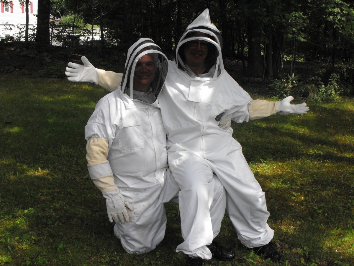 Beekeepers in protective bee suits, hats and gloves.