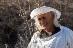 Retired Man with a beekeeper's veil on.